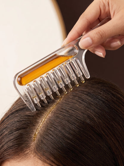Applicator comb applying oil to scalp close-up
